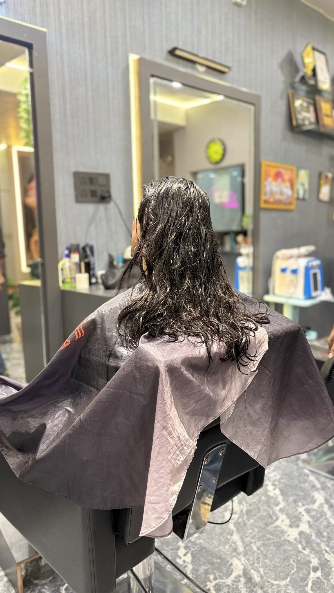 Stylist washing and preparing a client's hair at Romi's Family Salon, Satna